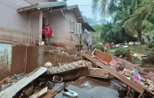 Equipe da Cáritas RS ajudando na limpeza de uma casa enlameada pela enchente no Rio Grande do Sul