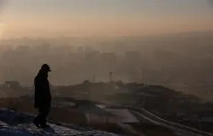 Homem observa a fumaça subindo sobre as casas em Ulaanbaatar, capital da Mongólia.