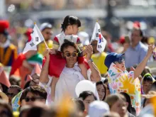 Criança com bandeiras sul-coreanas na praça de São Pedro durante missa celebrada pelo papa Francisco