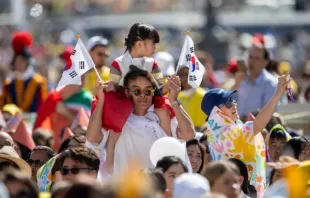 Criança com bandeiras sul-coreanas na praça de São Pedro durante missa celebrada pelo papa Francisco