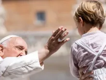 Imagem ilustrativa do papa Francisco saudando um menino durante a audiência geral