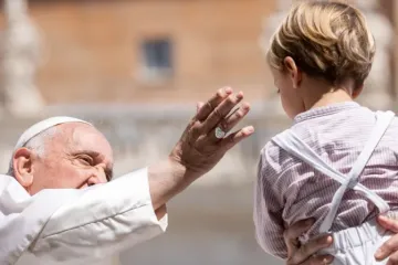 Imagem ilustrativa do papa Francisco saudando um menino durante a audiência geral