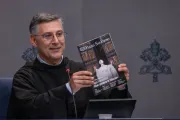 Padre Enzo Fortunato, diretor de comunicações da Basílica de São Pedro, segura uma cópia da primeira edição da nova revista mensal do Vaticano, "Piazza San Pietro".