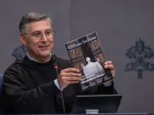 Padre Enzo Fortunato, diretor de comunicações da Basílica de São Pedro, segura uma cópia da primeira edição da nova revista mensal do Vaticano, "Piazza San Pietro".