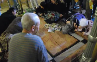 Peregrinos realizam práticas devocionais na Basílica do Santo Sepulcro em Jerusalém.