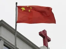 Bandeira chinesa tremula ao lado de cruz em igreja em Pingtan, China, em 15 de janeiro de 2024.