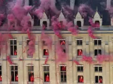 Nuvens de fumaça perto de janelas enquanto artistas participam da cerimônia de abertura das Olimpíadas Paris 2024 na sexta-feira (26).