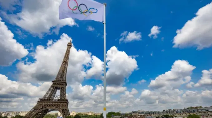 Bandeira olímpica em estádio próximo à torre Eiffel ?? 