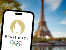 Logotipo das Olimpíadas Paris 2024 com a Torre Eiffel ao fundo.