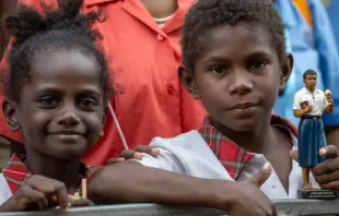 Duas crianças, uma delas segurando uma estátua do beato Pedro To Rot, aguardam no sábado (7) a visita do papa Francisco à Escola Secundária Técnica da Caritas em Port Moresby, Papua-Nova Guiné.