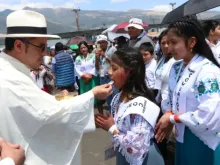 Padre dá a comunhão a crianças ontem (8) no 53º Congresso Eucarístico Internacional 2024, em Quito, Equador.