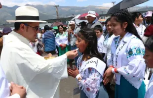 Padre dá a comunhão a crianças ontem (8) no 53º Congresso Eucarístico Internacional 2024, em Quito, Equador.