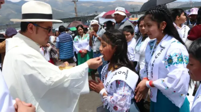 Padre dá a comunhão a crianças  no Congresso Eucarístico Internacional 2024 ?? 