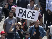 Peregrinos na praça de São Pedro, no Vaticano, com faixa que diz "Pace" ("Paz", em italiano).