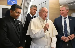 Papa Francisco fala a jornalistas a bordo do avião papal com destino à Mongólia, com o futuro cardeal George Jacob Koovakad à esquerda, em 31 de agosto de 2023.