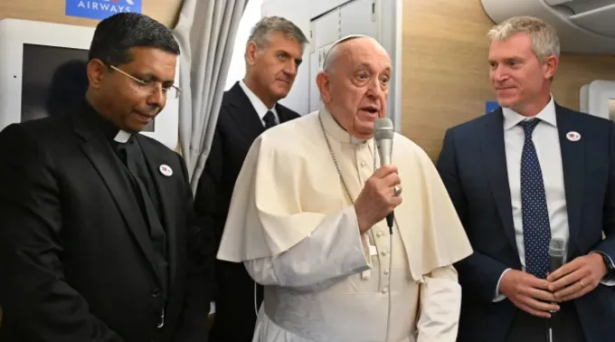 Papa Francisco fala a jornalistas a bordo do avião papal com o futuro cardeal George Jacob Koovakad ?? 