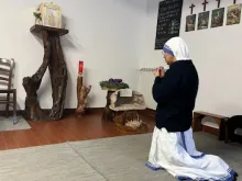 Freira se ajoelha diante de sacrário depois de convidar um grupo de mulheres que doam presentes de Natal a rezar na casa das missionárias da Caridade em Roma.