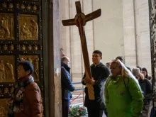 Peregrinos cruzam a porta santa da basílica de São Pedro, no Vaticano.