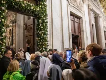 Peregrinos passam pela porta santa da Basílica de Santa Maria Maior, em Roma.