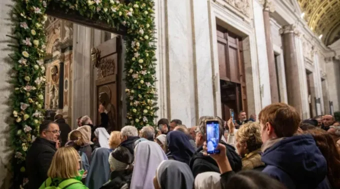 Fiéis se reúnem na porta santa enfeitada com flores da basílica de Santa Maria Maior ?? 