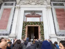 Peregrinos cruzam a porta santa da basílica de São Paulo Fora dos Muros, em Roma.