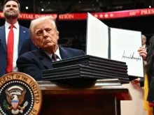 O presidente dos EUA, Donald Trump, segura ordem executiva que assinou ontem (20) em desfile inaugural na Capital One Arena em Washington, D.C., EUA.