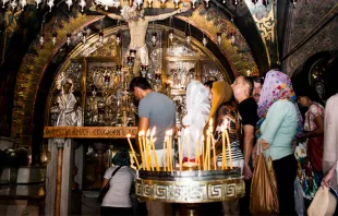 Peregrinos rezam no lugar da crucificação, dentro da Basílica do Santo Sepulcro em Jerusalém.