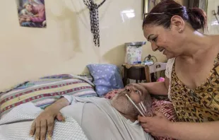 Um cristão doente recebe atendimento médico em sua casa na Síria.