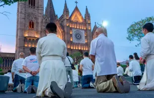 Homens rezam em frente à Catedral de Guadalajara