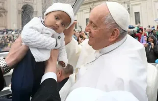 O papa Francisco cumprimenta uma criança durante a audiência geral