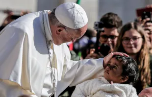 Papa abençoa uma menina ao início da Audiência Geral.