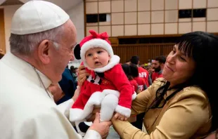 Papa Francisco abençoa uma criança na Sala Paulo VI.