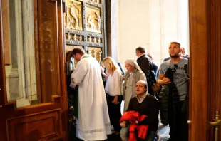 Peregrinos cruzando a Porta Santa da Basílica de São Pedro 