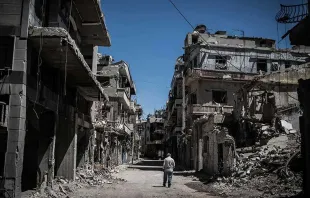 Refugiado percorre ruas destruídas no centro de Homs, na Síria.