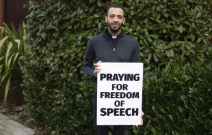 Padre Sean Gough com sua placa dizendo rezo pela liberdade de expressão'