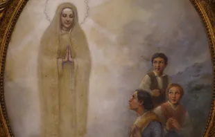 Um quadro da Virgem de Fátima e os pastorinhos no santuário em Portugal.