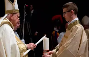 Zane segura o círio pascal enquanto o papa Francisco a acende, na Vigília Pascal no Sábado Santo de 2023 no Vaticano.